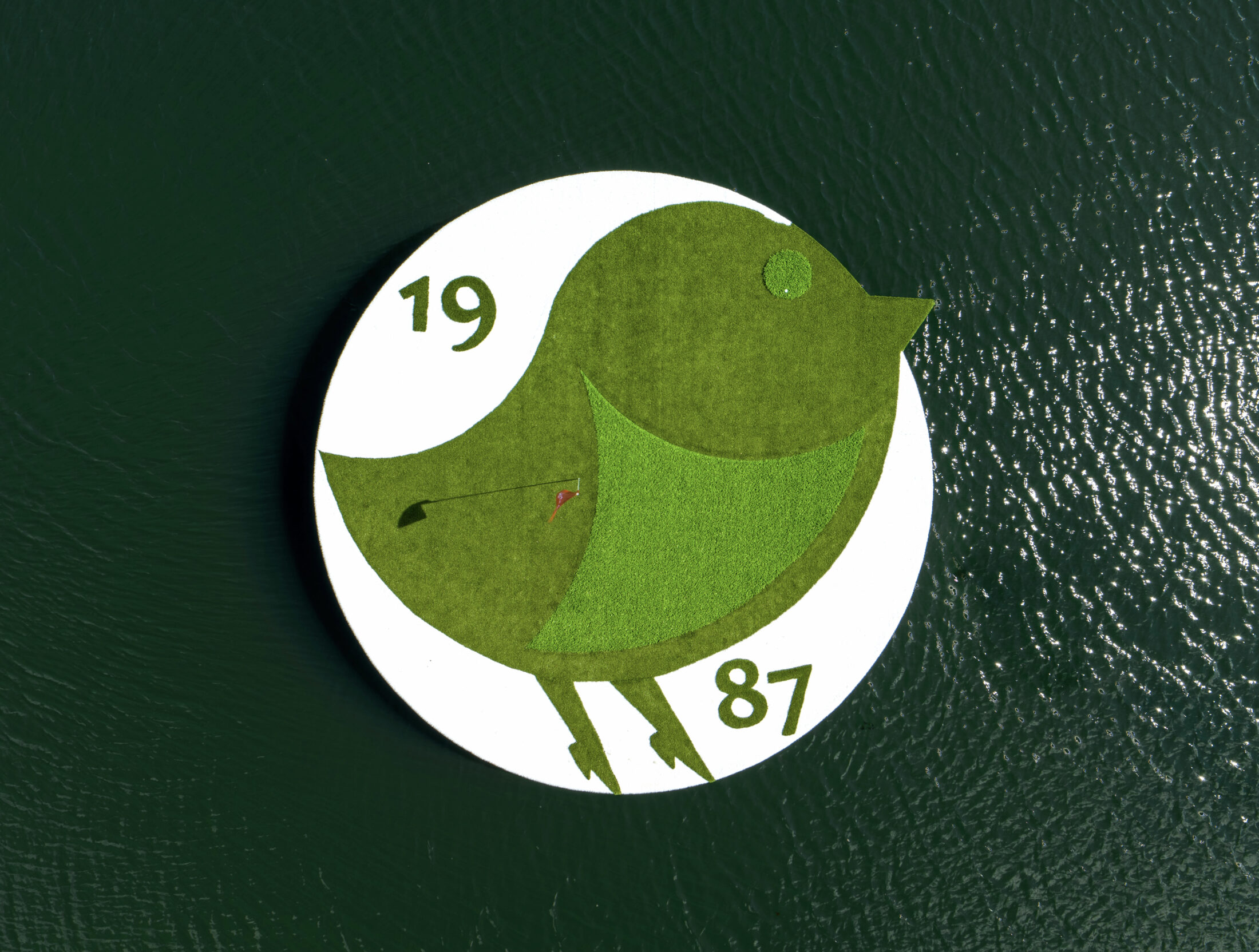 Bird Logo with 1987 on island green Nemacolin