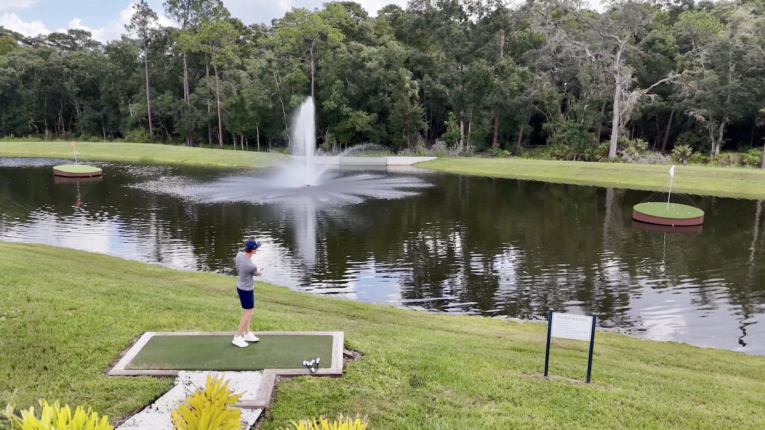 Golfer shooting to a floating golf green with a sprinkler to the left